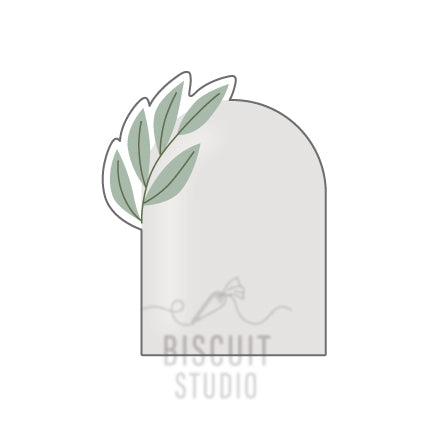 A cookie cutter in the shape of an arch plaque with leaf accents, designed by Biscuit Studio.