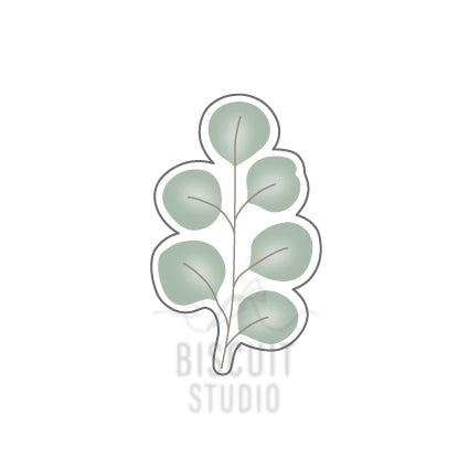 A cookie cutter in the shape of an eucalyptus branch with green leaves by Biscuit Studio.