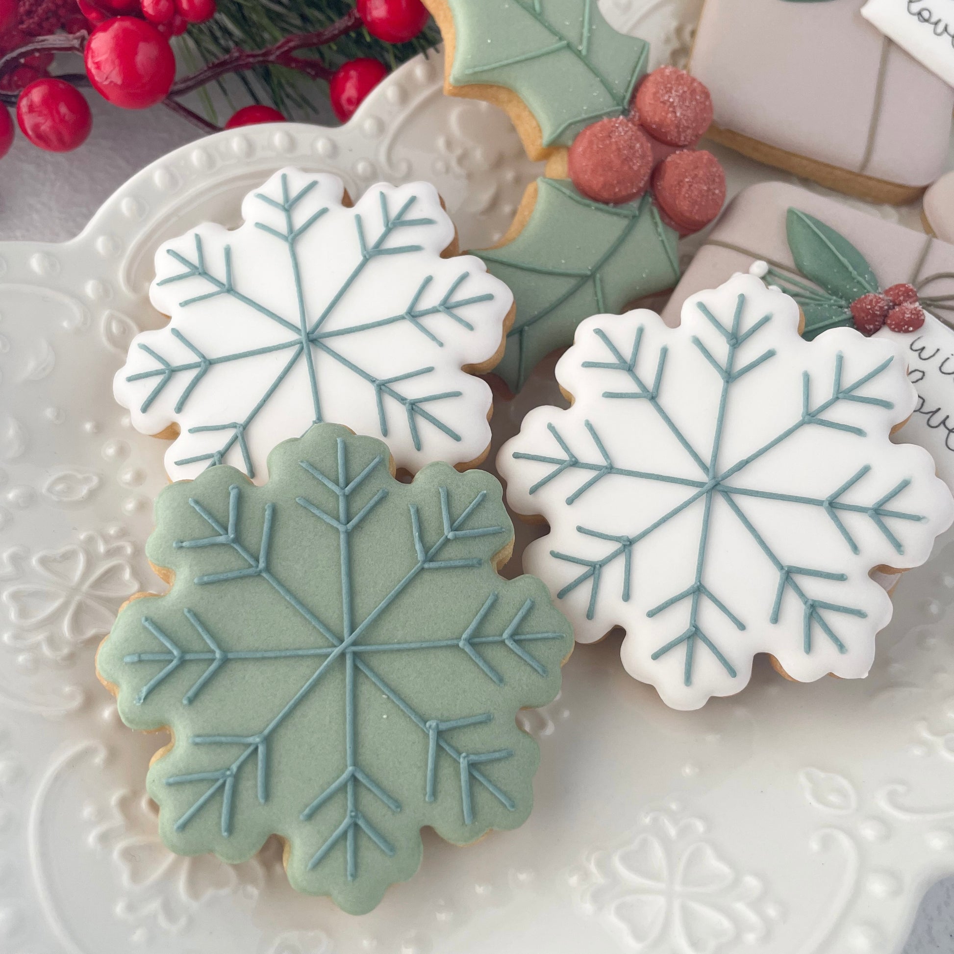 Decorative cookies with snowflake designs on a white plate.