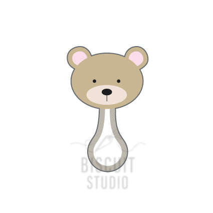 A cookie cutter in the shape of a teddy bear rattle, designed by Biscuit Studio.